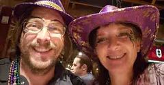 Two people with mardi gras face paint and hats